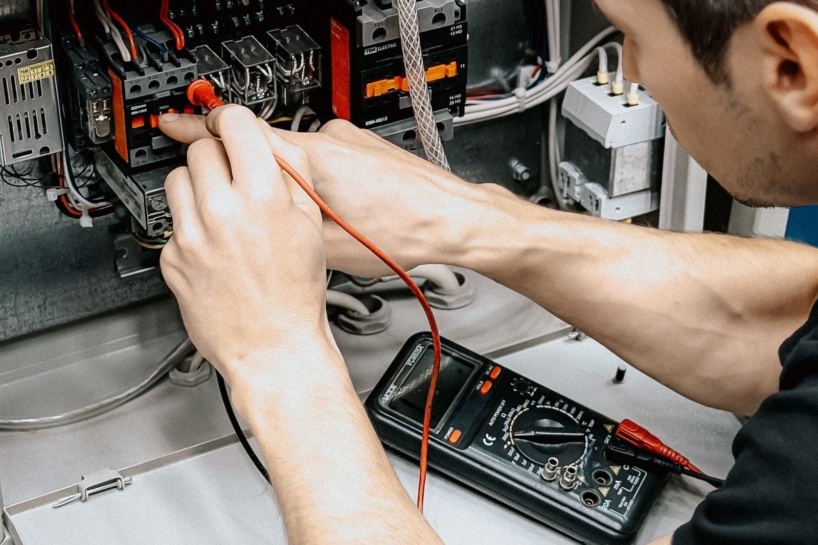 Electricista comprobando un cuadro eléctrico con un multímetro